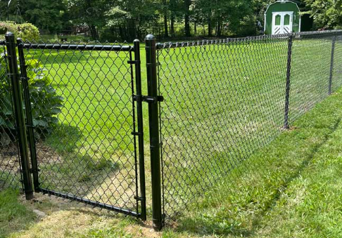 Black vinyl-coated chain link fence with gate in a residential backyard