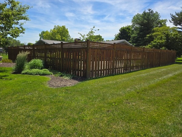 Wood board-on-board fence with lattice top surrounding a backyard in Shelbyville, IN